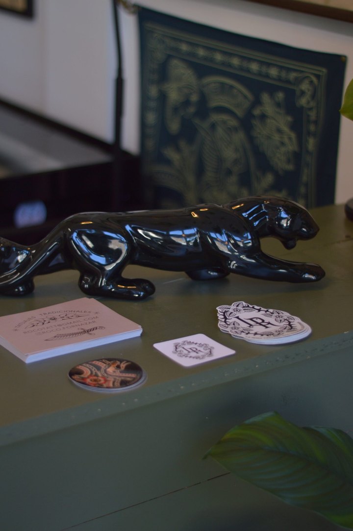The front desk at La Rosa: a black panther statue, business cards and rose-monogram stickers.