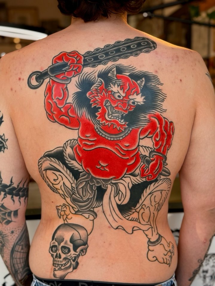 A Japanese oni demon holding a club, tattooed across a full back.