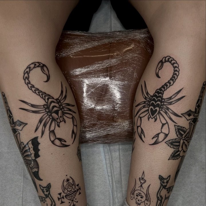 Matching scorpions tattooed on the backs of both calves